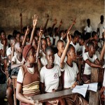 Children in African Classroom with Hands Raised